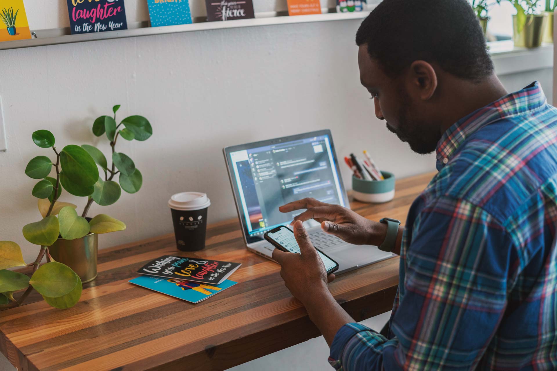 Man with phone and laptop at desk